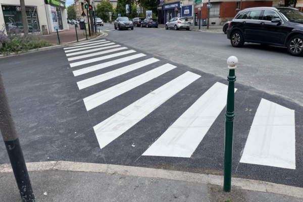 Passage piéton blanc sur une chaussée refaite en centre-ville.